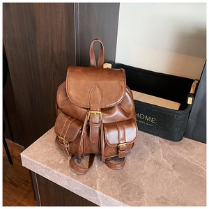 Primer plano de mochila de cuero marrón vintage con hebillas de latón y cordón ajustable