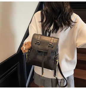 Fashionable black PU leather backpack with gold buckles and brown plush bear charm