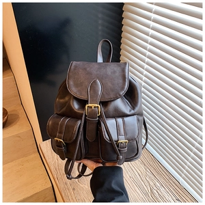 Vista detallada de una mochila vintage de cuero sintético marrón oscuro con hebillas
