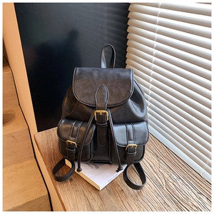 Detalle de mochila vintage de cuero negro con hebillas de metal y cierre de cordón