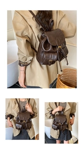 Detail view of vintage dark brown travel backpack with metal buckles and drawstring closure