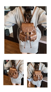 Detail view of brown vintage leather backpack with metal buckles and multiple pockets