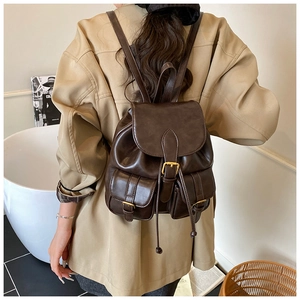 Detail of vintage dark brown PU leather backpack with buckle straps and drawstring