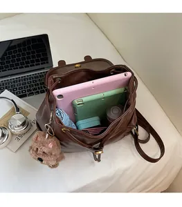 Top view of spacious brown faux leather backpack interior with gadgets and accessories