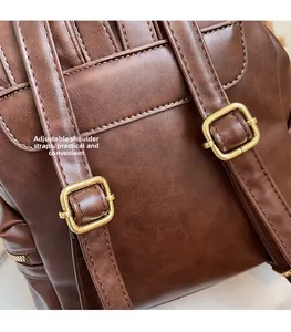 Detail of adjustable dark brown faux leather backpack straps with metal buckle