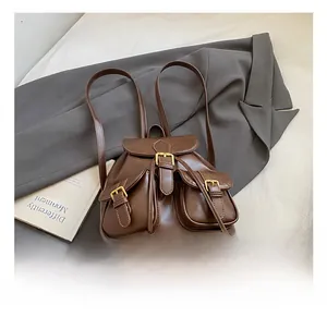 Close-up of vintage brown PU leather backpack featuring triple front pockets and metal buckles