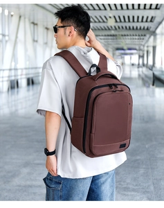 Side view of brown expandable travel backpack for men shown in an airport setting