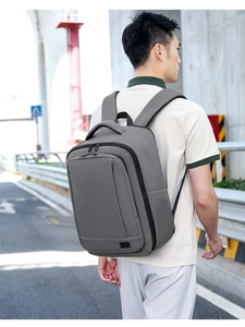 Detail view of large capacity dark grey business backpack on model in urban setting