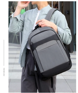 Close-up of a grey and black business backpack with multiple functional zipper pockets