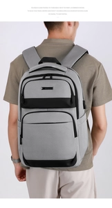 Détail du sac homme gris montrant le port USB externe et les fermetures à glissière