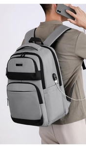Détail du sac de poitrine gris clair montrant le port de charge USB et le compartiment zippé