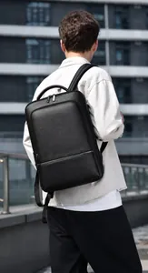 Close-up of black lychee grain leather backpack for men in a modern urban outdoor setting