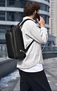 Rear view of black leather business backpack with external USB charging port in city setting