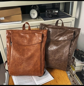 Détail de sacs à dos vintage en cuir synthétique avec texture cirée et zips latéraux