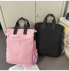 Vue détaillée des sacs à dos en toile rose et noir avec poches latérales et poignées