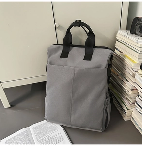 Sac à dos en toile grise avec poche frontale et porte-bouteille latéral, décor moderne