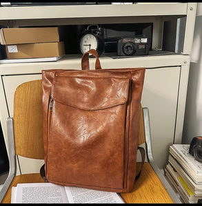 Détail du sac à dos vintage en cuir marron sur une chaise en bois avec décor rétro