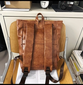 Vue détaillée du dos d'un sac à dos vintage en cuir marron avec de larges bretelles