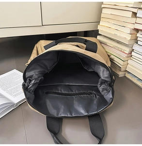 Vue intérieure du sac à dos kaki montrant le compartiment principal et la poche zippée