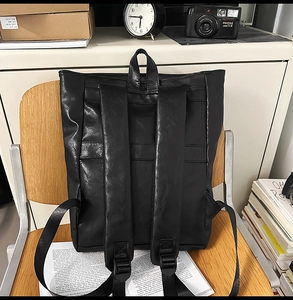 Détail des bretelles réglables du sac à dos en cuir noir vintage dans un cadre de vie