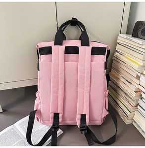 Vue arrière du sac à dos rose avec bretelles réglables noires et poches latérales sur bureau