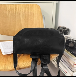Détail de la texture en cuir noir du sac à dos et des bretelles réglables durables