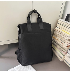 Détail d'un sac à dos noir grande capacité avec doubles poignées et poches latérales