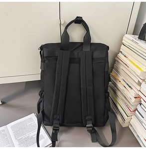 Vue arrière du sac à dos en toile noire avec bretelles réglables et double poignée