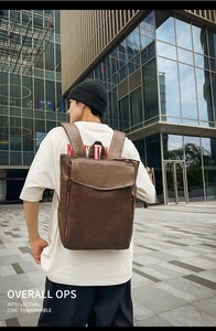Gros plan d'un sac à dos vintage en cuir marron porté par un mannequin en milieu urbain