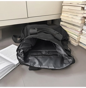 Vue détaillée du grand espace de rangement interne et de la poche zippée du sac à dos noir