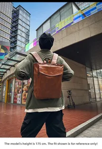 Vue arrière d'un mannequin portant un sac à dos vintage en cuir marron en ville