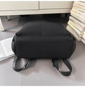 Détail des bretelles rembourrées noires et du fond robuste du sac à dos minimaliste chic