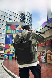 Détail d'un sac à dos vintage en cuir noir avec texture mate et poche latérale