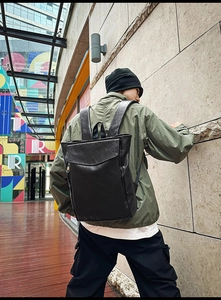 Gros plan du sac à dos en cuir noir minimaliste avec rabat et fermetures éclair cachées