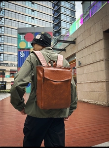 Gros plan d'un sac à dos vintage en cuir marron avec poche à rabat dans un décor urbain