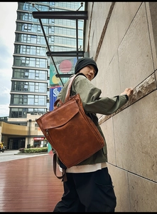 Gros plan du sac à dos vintage en cuir marron avec poche texturée et fermeture éclair