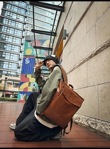 Photo en plein air d'un sac à dos vintage en cuir marron avec rabat pour la ville
