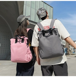 Détail de sacs à dos rose et gris avec poignées renforcées et poches latérales élastiques