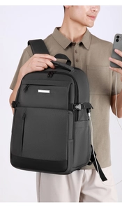 Détail du sac à dos gris montrant le port de charge USB externe connecté à un téléphone