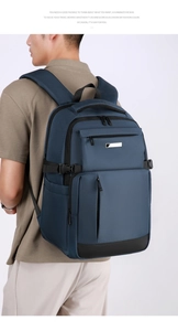 Détail du sac à dos ordinateur bleu foncé avec plusieurs poches zippées et boucles