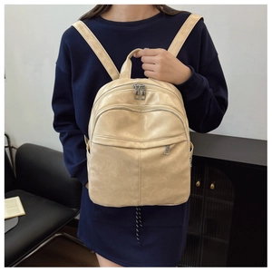 Detailed view of lightweight beige soft leather multi-pocket backpack worn by a model