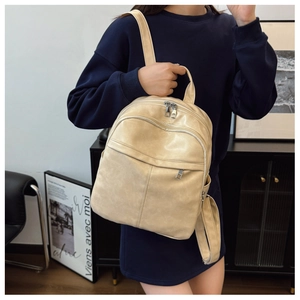 Beige faux leather backpack featuring a front zipper pocket and minimalist straps