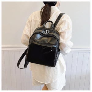 Classic black PU leather backpack with minimalist design shown on model for daily use