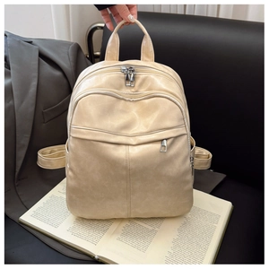 Close-up of cream soft leather backpack with zip pockets on a stylish office background