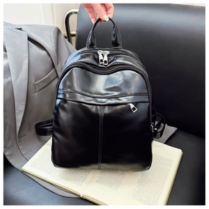 Detail showing high-quality black PU leather texture and silver zipper hardware of the backpack