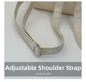 Detail of adjustable faux leather shoulder strap with silver buckle on beige backpack