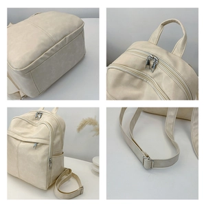 Detail view of cream PU leather backpack featuring multi-zipper layers and adjustable straps