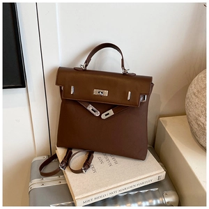 Detail view of the brown matte handbag showing silver metal twist lock and texture