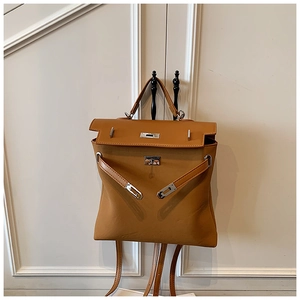Detail of caramel leather backpack featuring iconic metal turn-lock and top handle