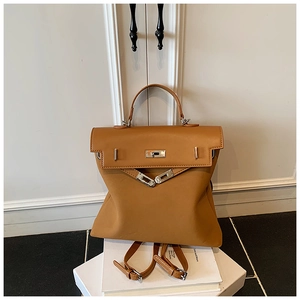 Detail of caramel leather backpack featuring Kelly-style silver lock and top handle